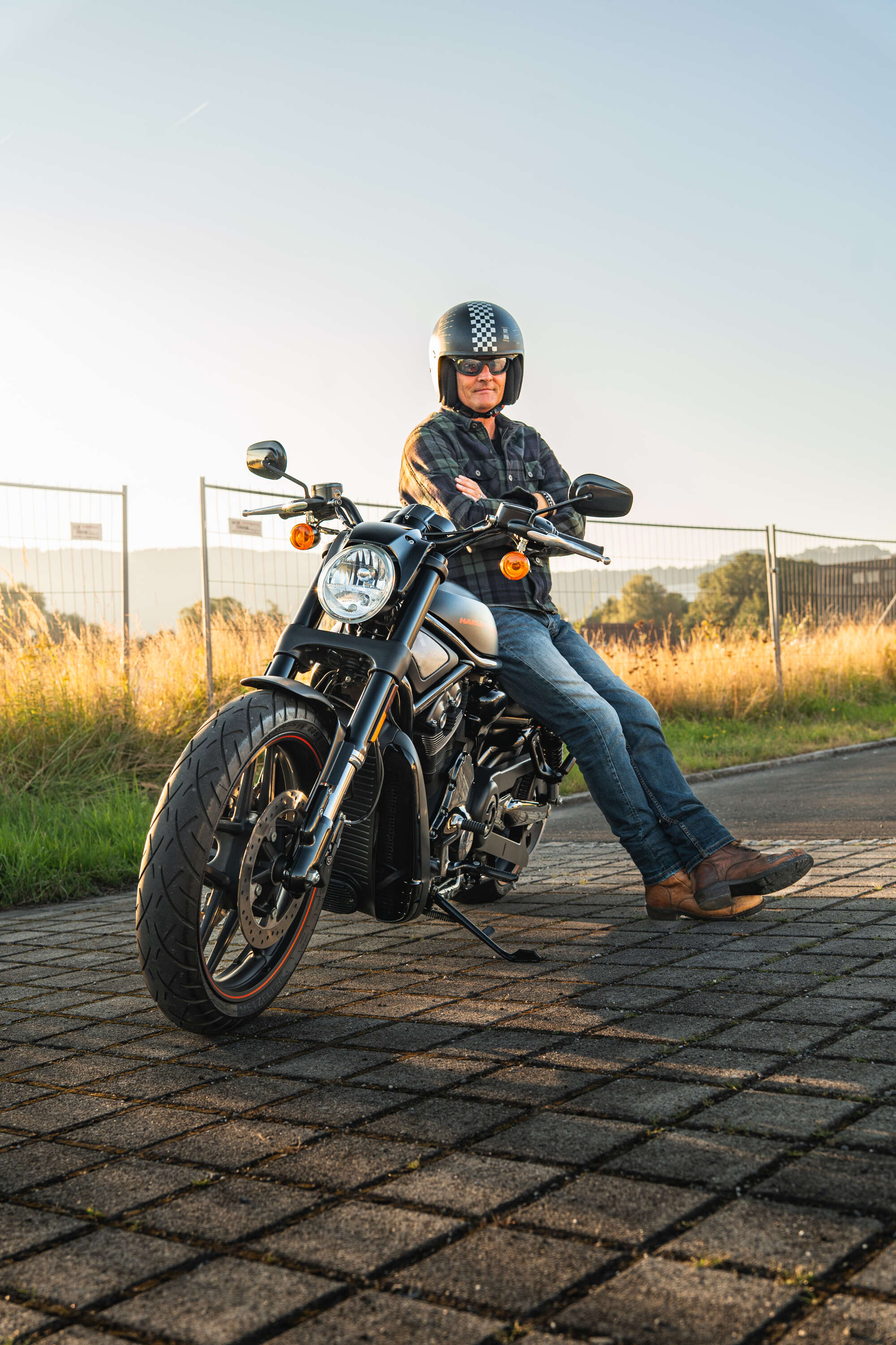 Mann mit Motorrad bei goldenem Licht
